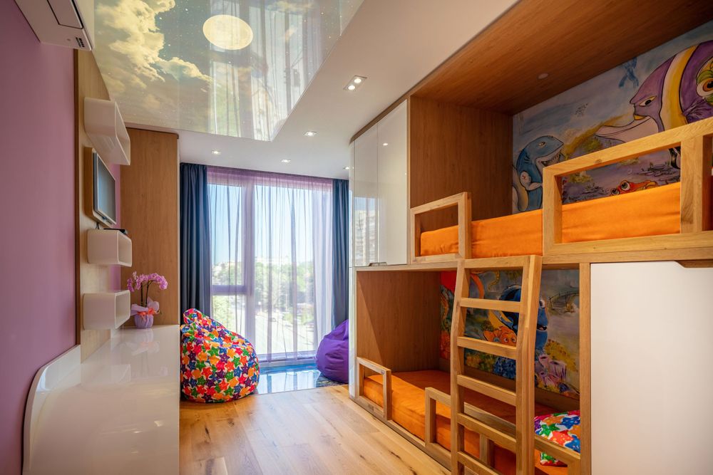 Colorful children's bedroom with bunk beds, cloud ceiling design, and large window with natural light.