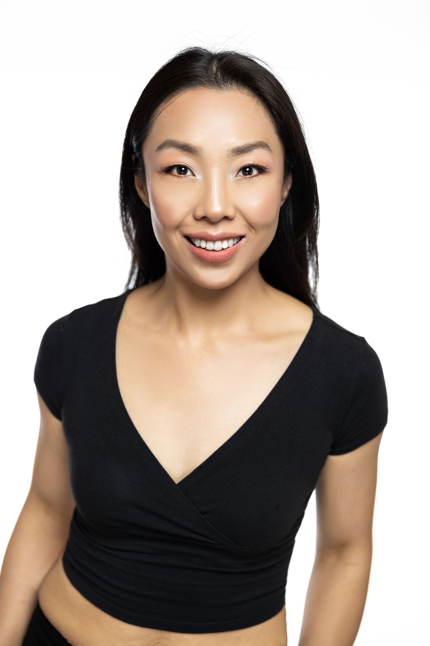 Portrait of person in black wrap top against white background.
