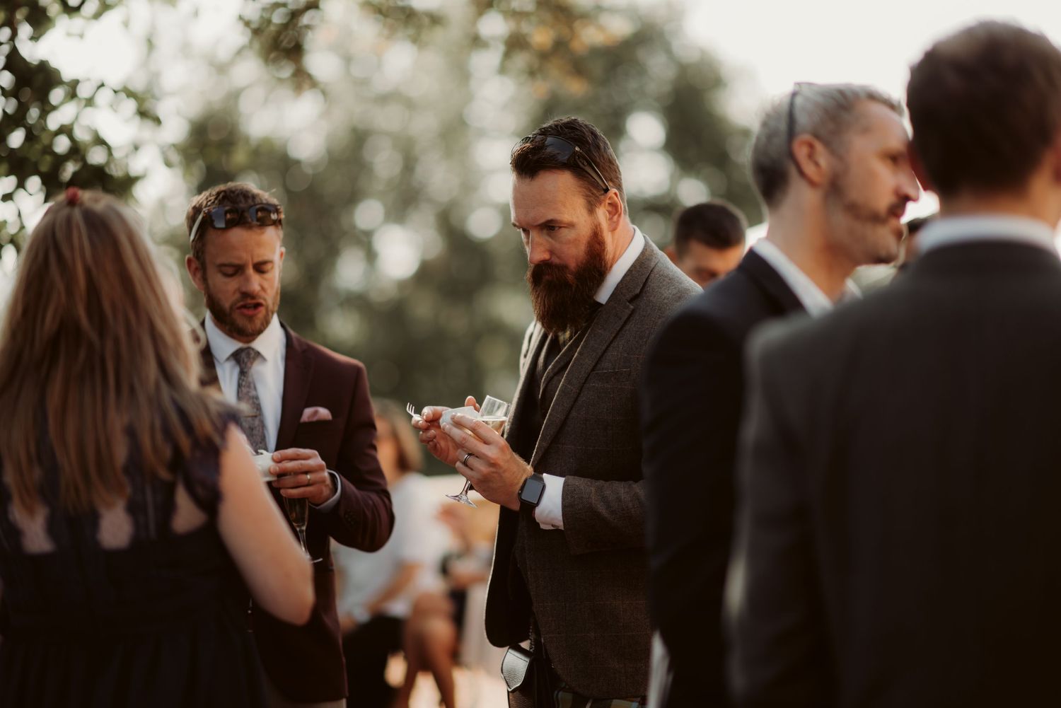 Wedding guests mingling and socializing at an outdoor cocktail reception.