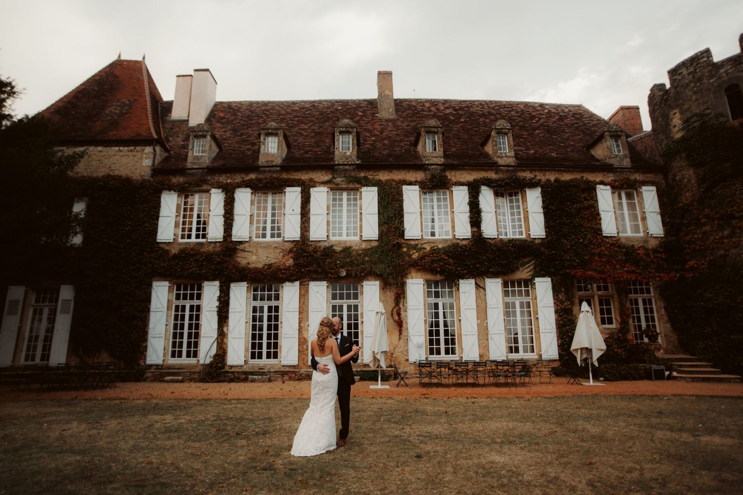 Elegant French manor house wedding venue with classic shuttered windows and symmetrical architecture.