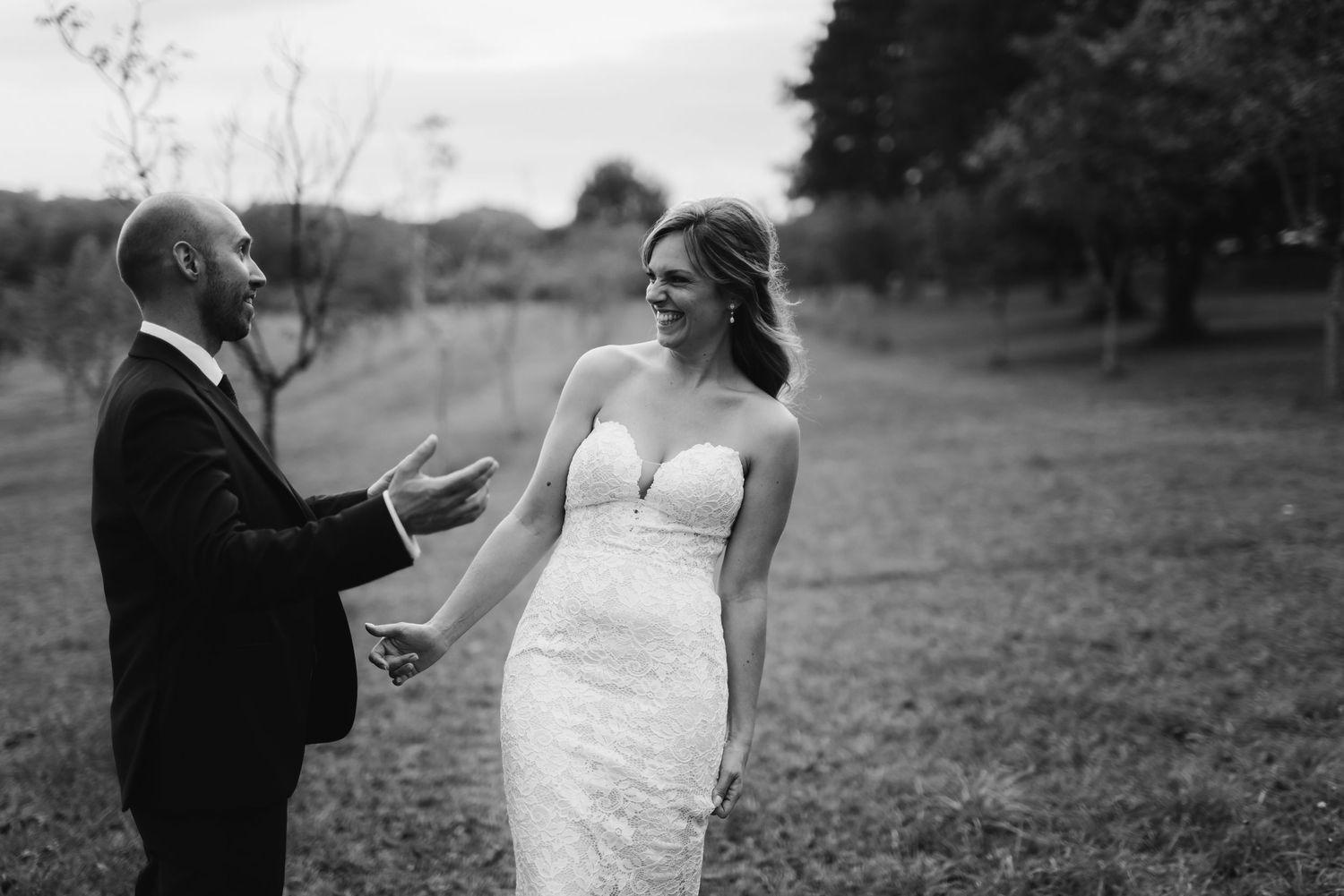 A wedding couple shares a moment during their ceremony in a natural outdoor setting.