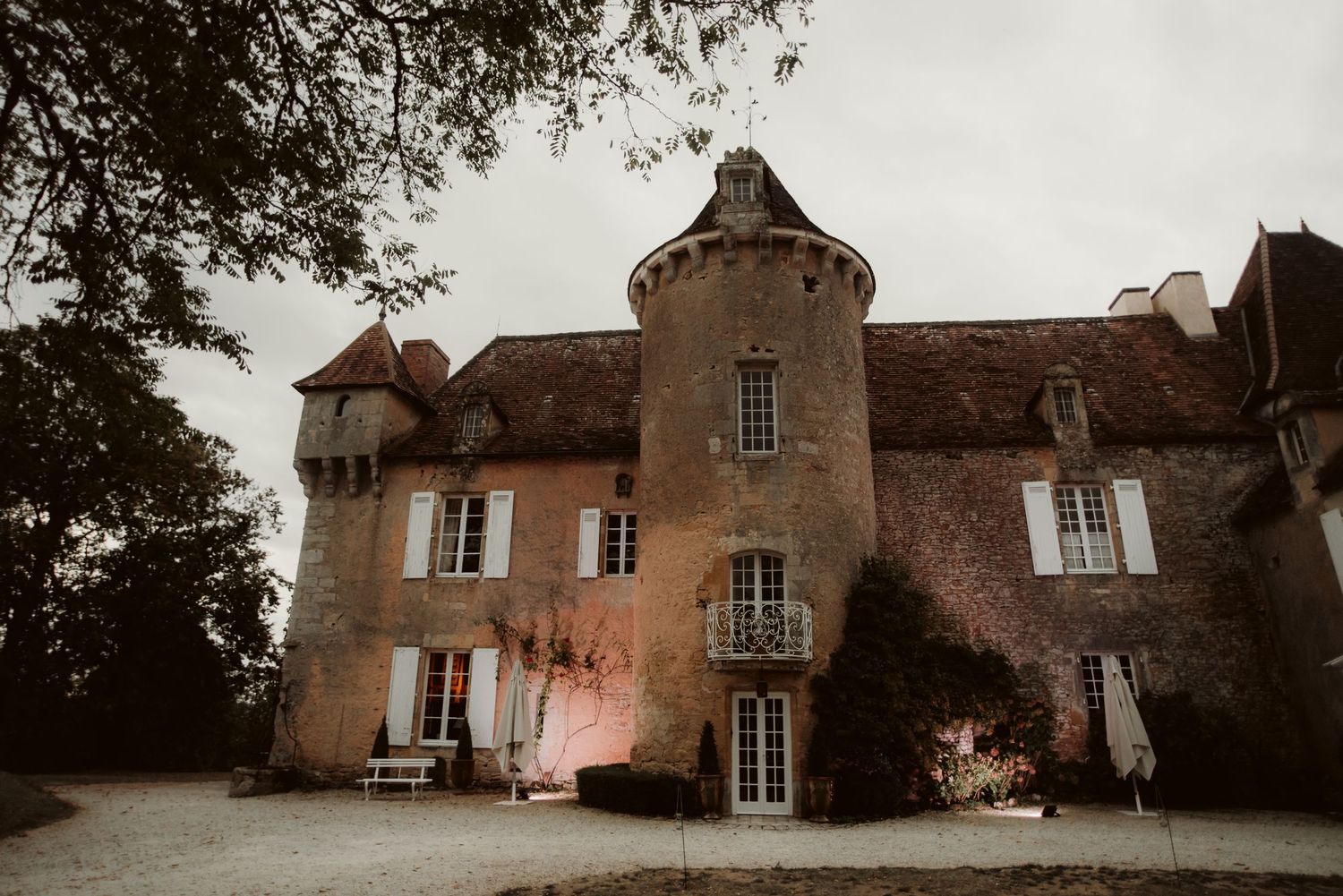 Elegant French countryside manor with circular tower and classic architectural details.