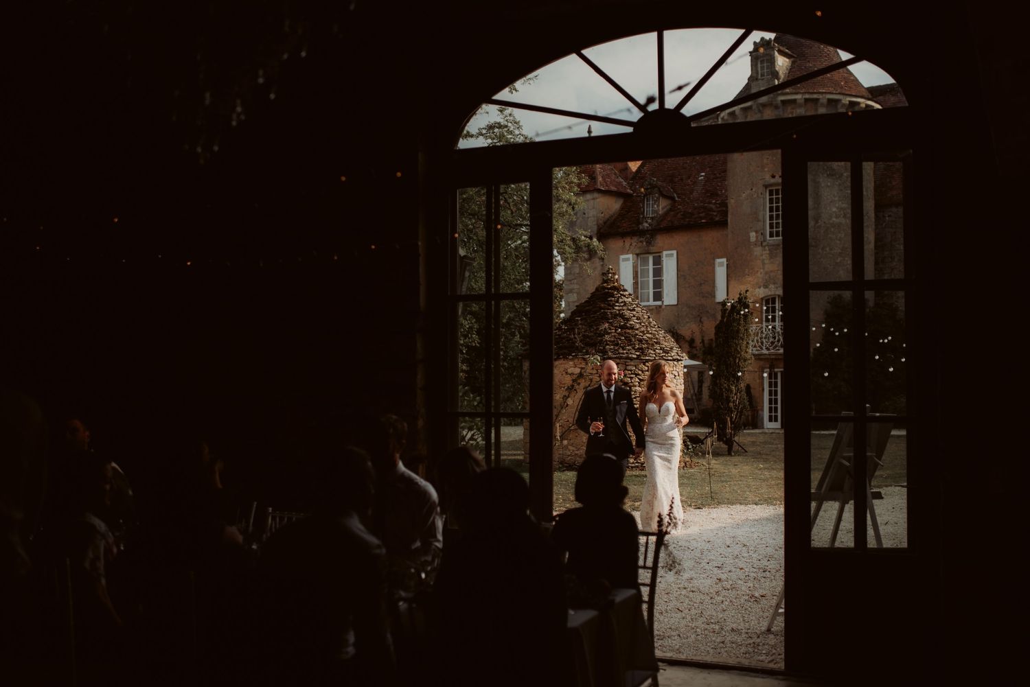 Wedding celebration viewed through an elegant arched doorway at a historic venue.