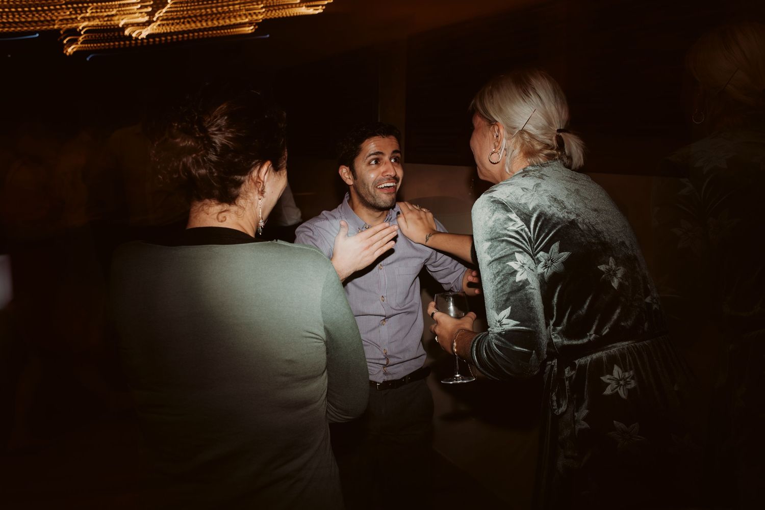 Guests enjoy drinks and conversation during an evening wedding reception.