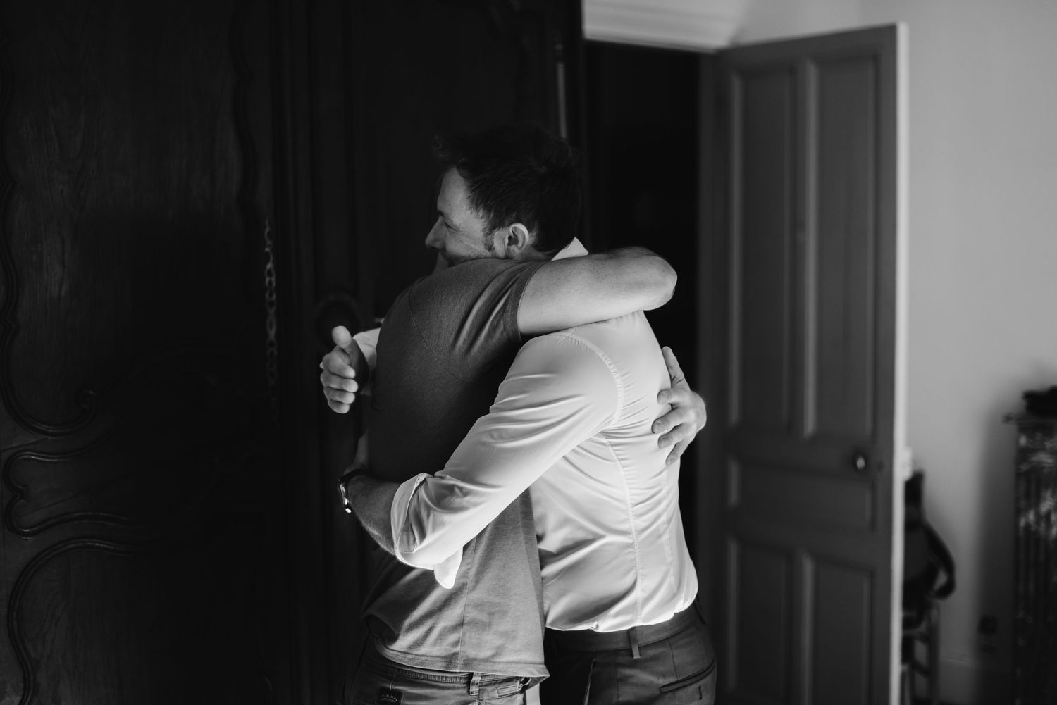 Emotional embrace captured in black and white with soft natural lighting.