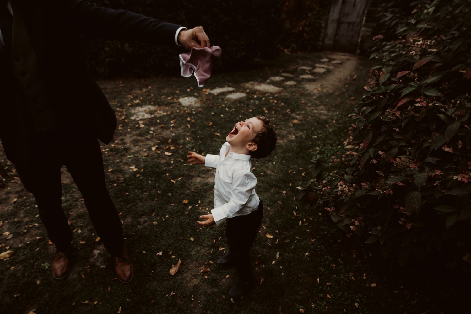 A joyful moment captured in a moody forest setting with light filtering through trees.