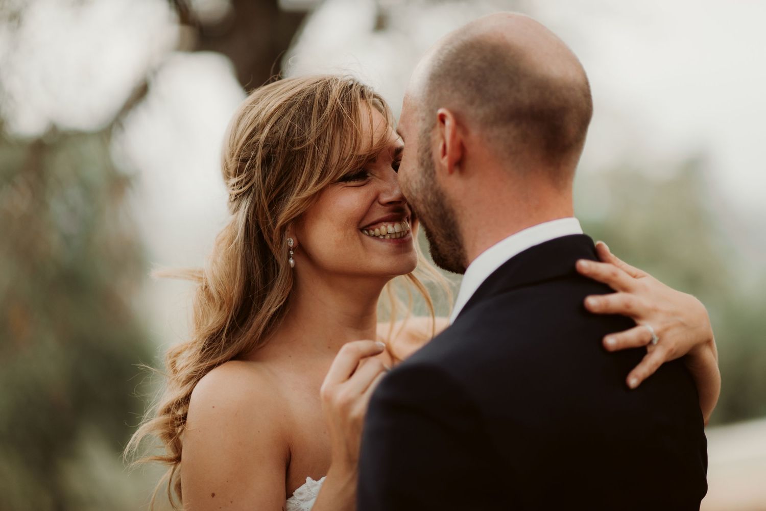 Joyful wedding moment shared between couple in soft natural lighting.