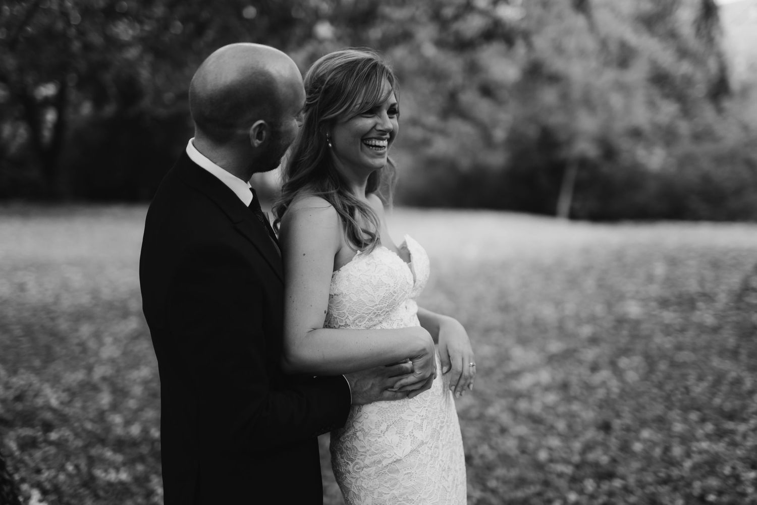 Black and white portrait of couple sharing joyful moment in outdoor setting.