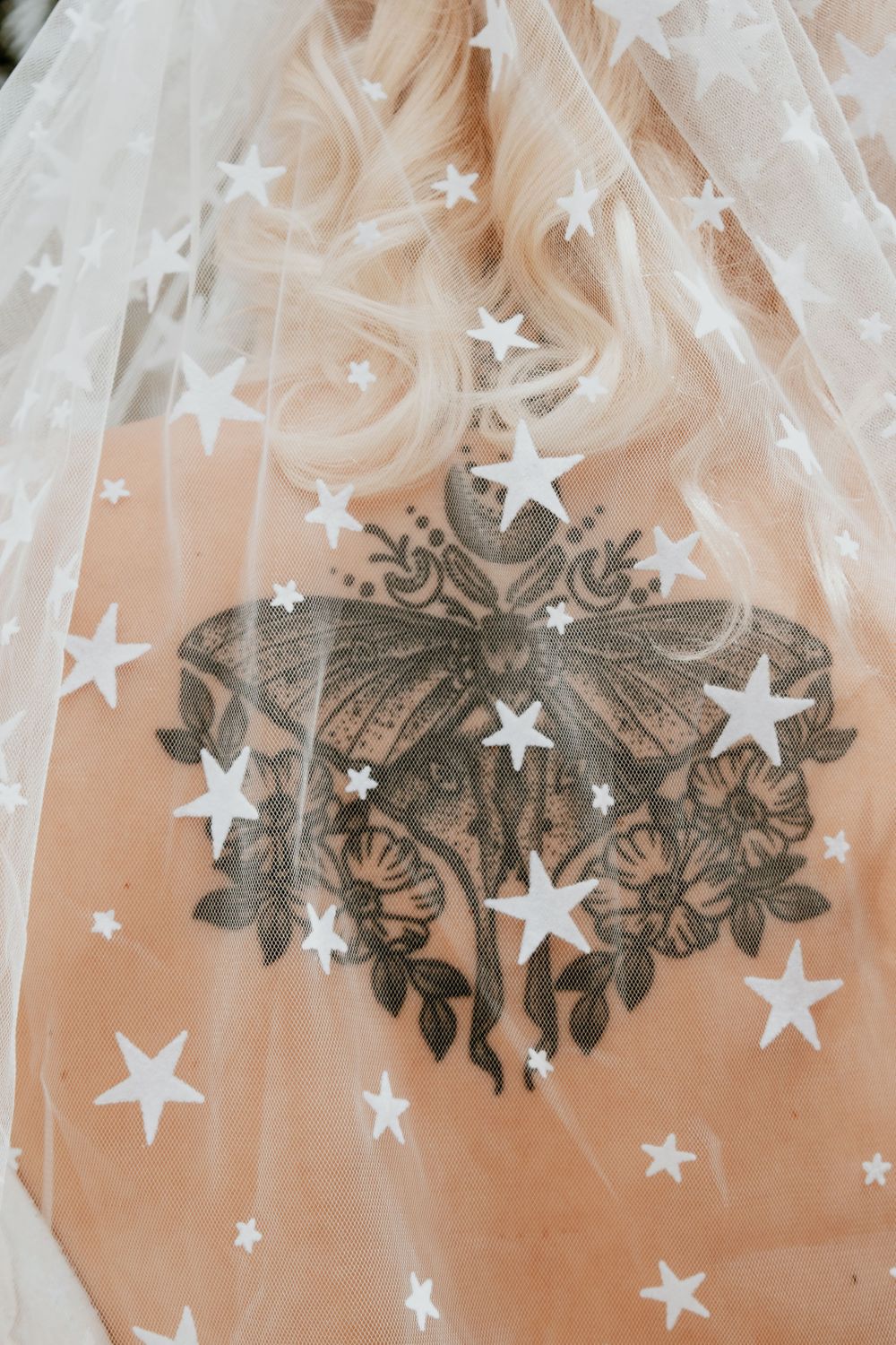 Delicate white star decorations hanging from floral metalwork in an ethereal display.