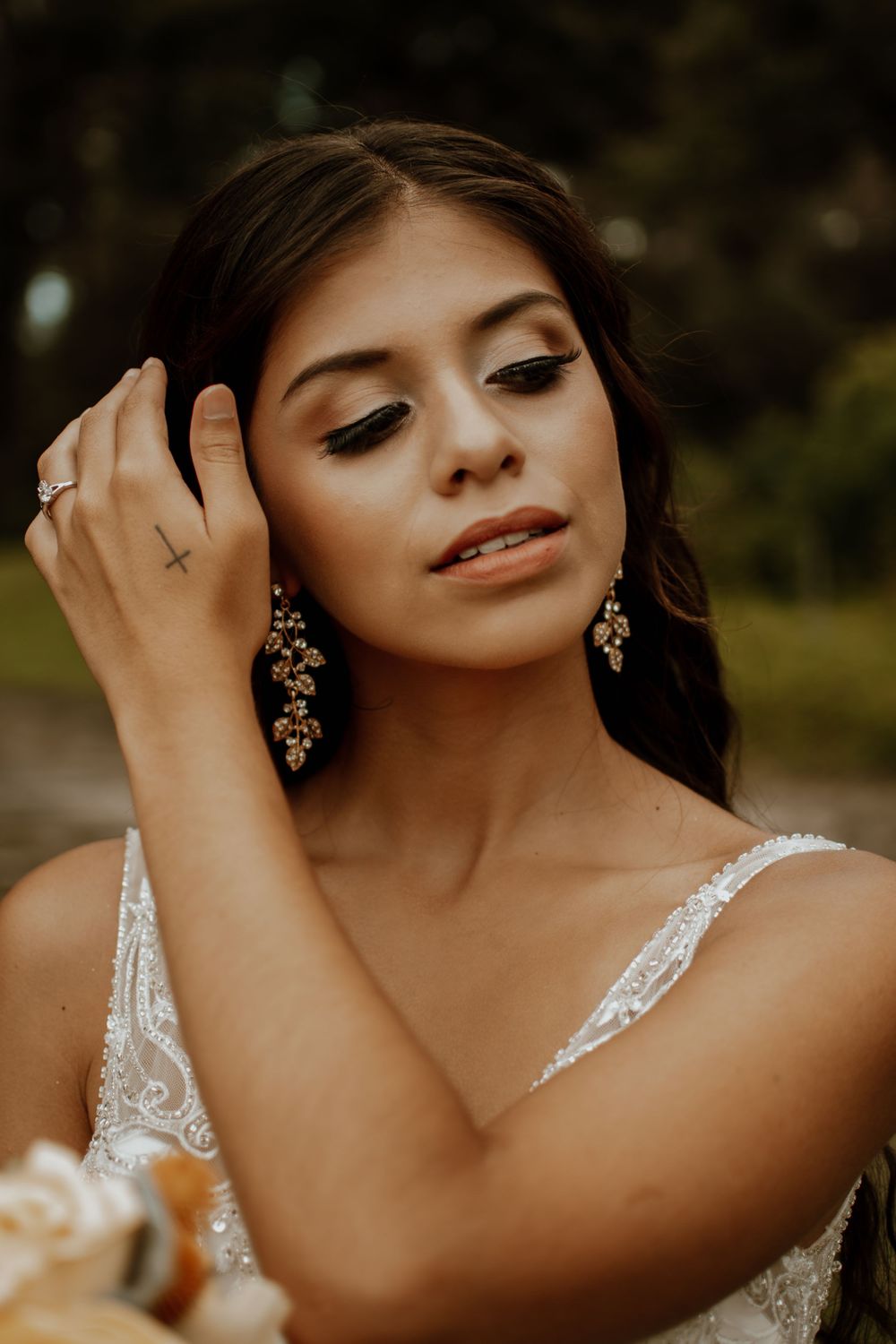 Elegant bridal portrait showcasing sparkling earrings and lace details.