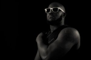 Dramatic low-key photo of person in white sunglasses with dark shadows.