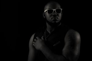 Minimalist portrait featuring person in sunglasses with strong contrast lighting.