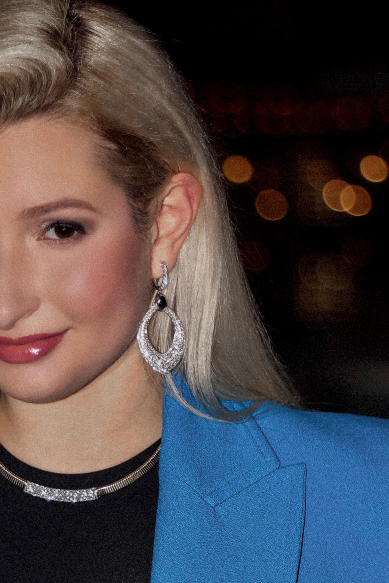 Glamorous evening portrait featuring sparkly statement earrings and bright blue blazer.