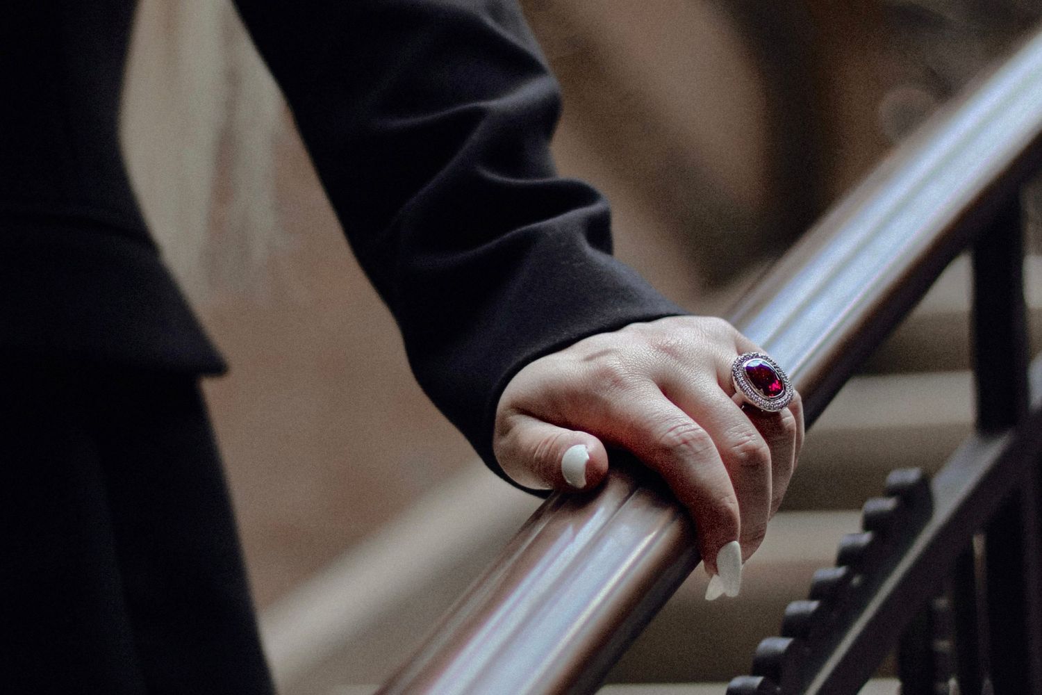 Close-up of hands resting on piano keys showing elegant ring.