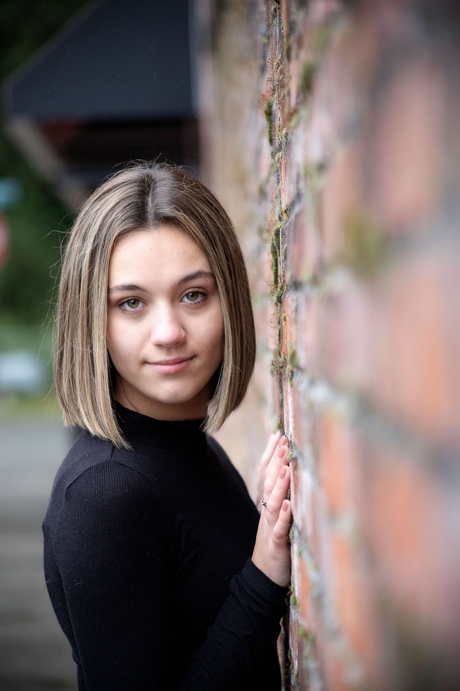 Artistic portrait sequence showing different poses against a brick wall.
