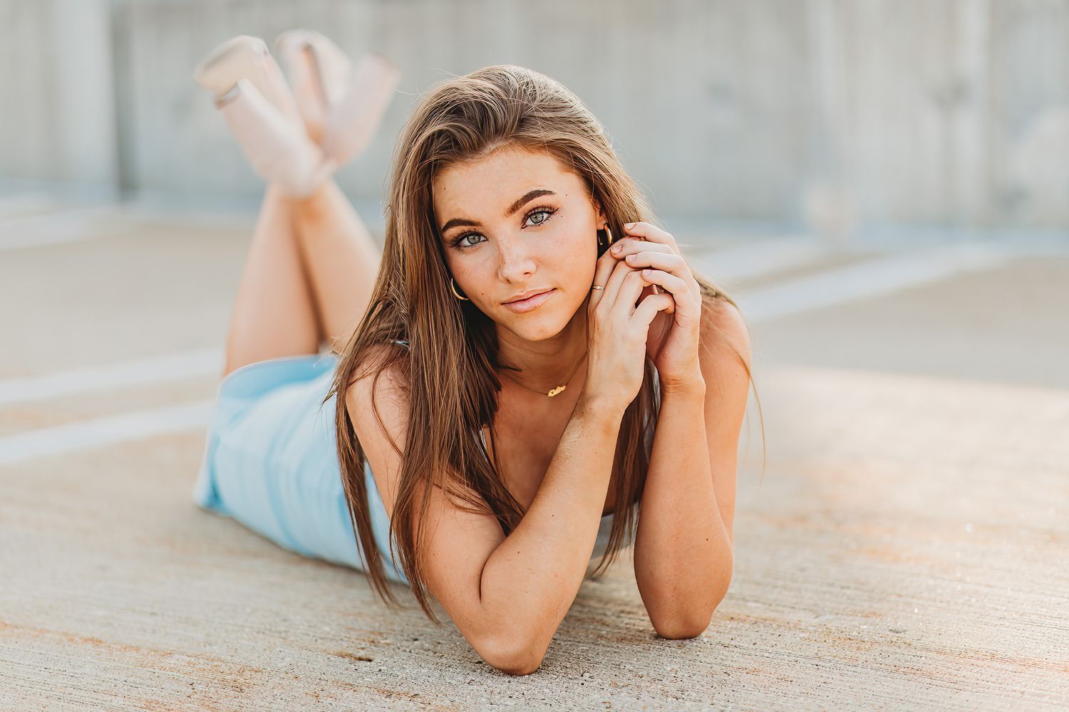 Outdoor portrait photography session on stone pavement with flowers in golden sunlight.