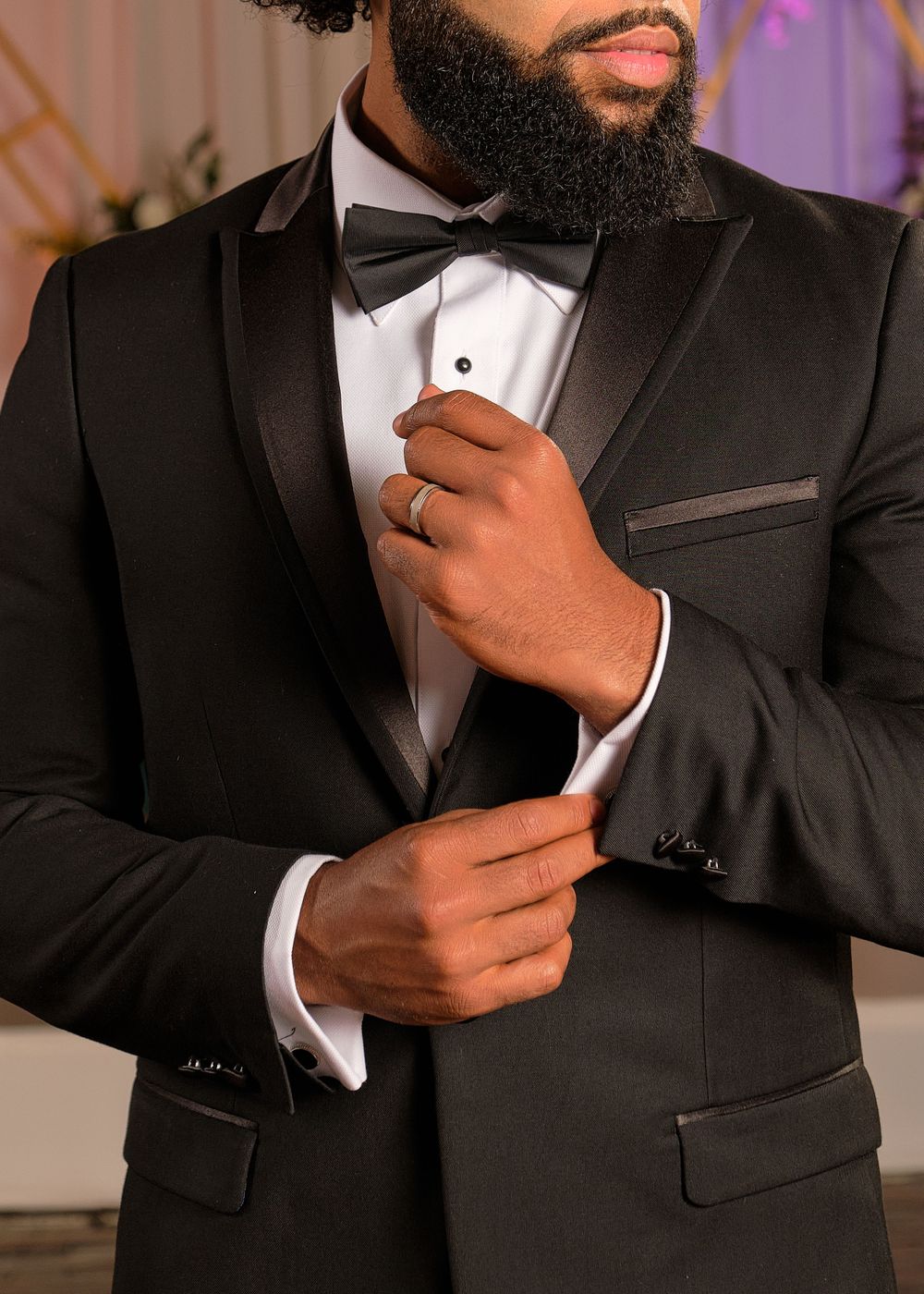 Close-up of formal black tuxedo with bowtie and elegant cufflinks.