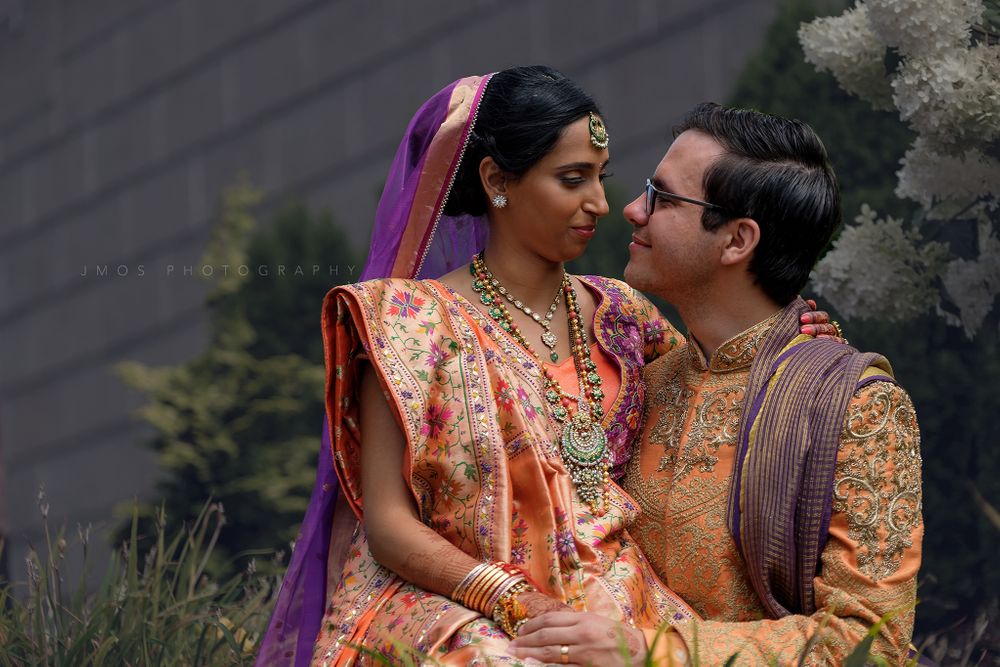 Couple in traditional Indian wedding attire sharing intimate moment.