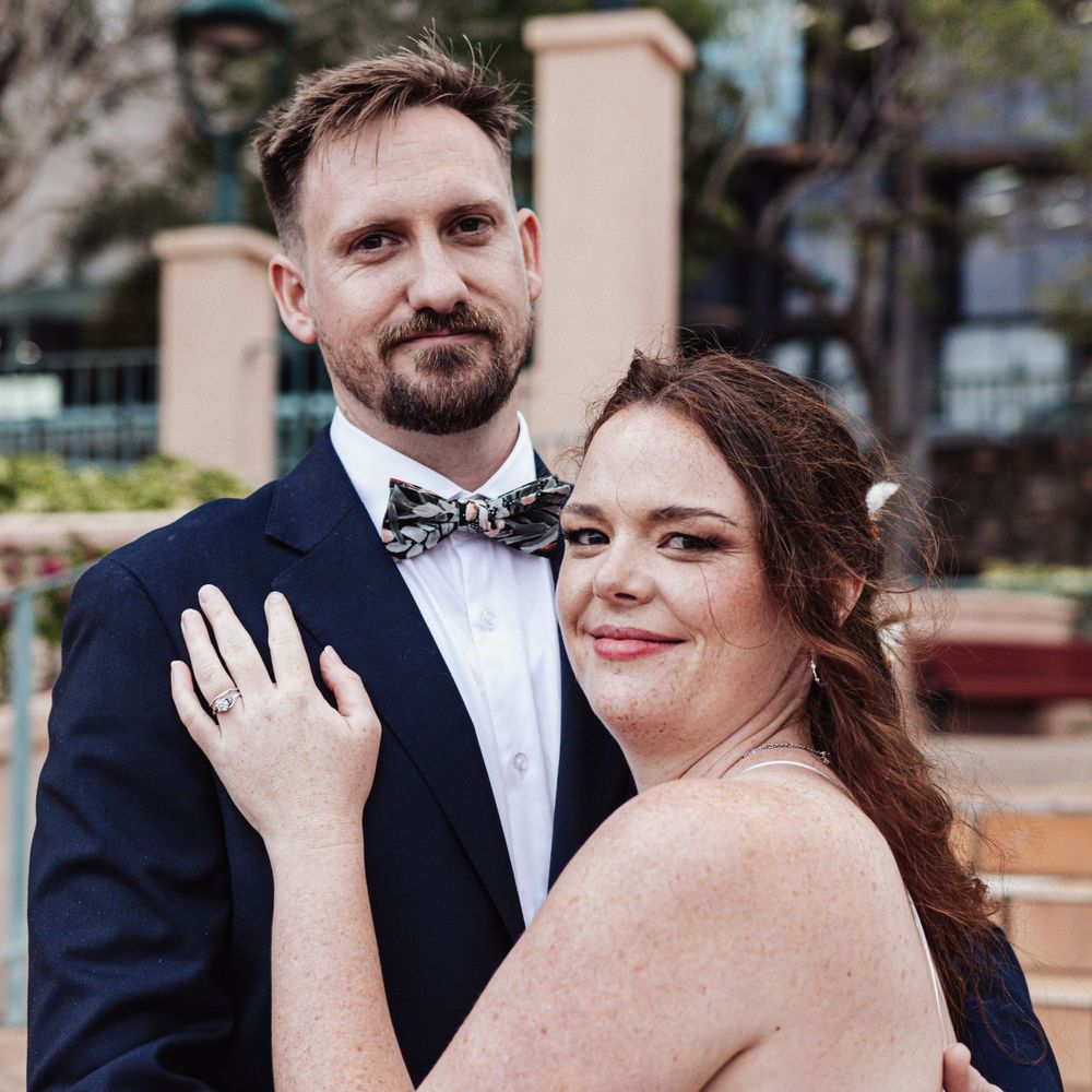 Bride and groom sharing a romantic moment outdoors in formal wedding attire.