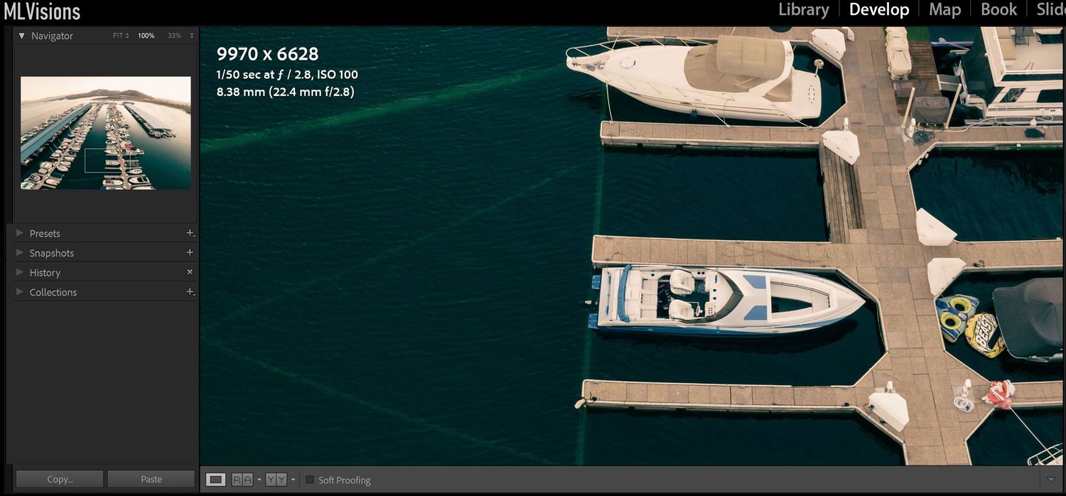 Dark teal-toned photo editing workspace displaying marina images in post-production.