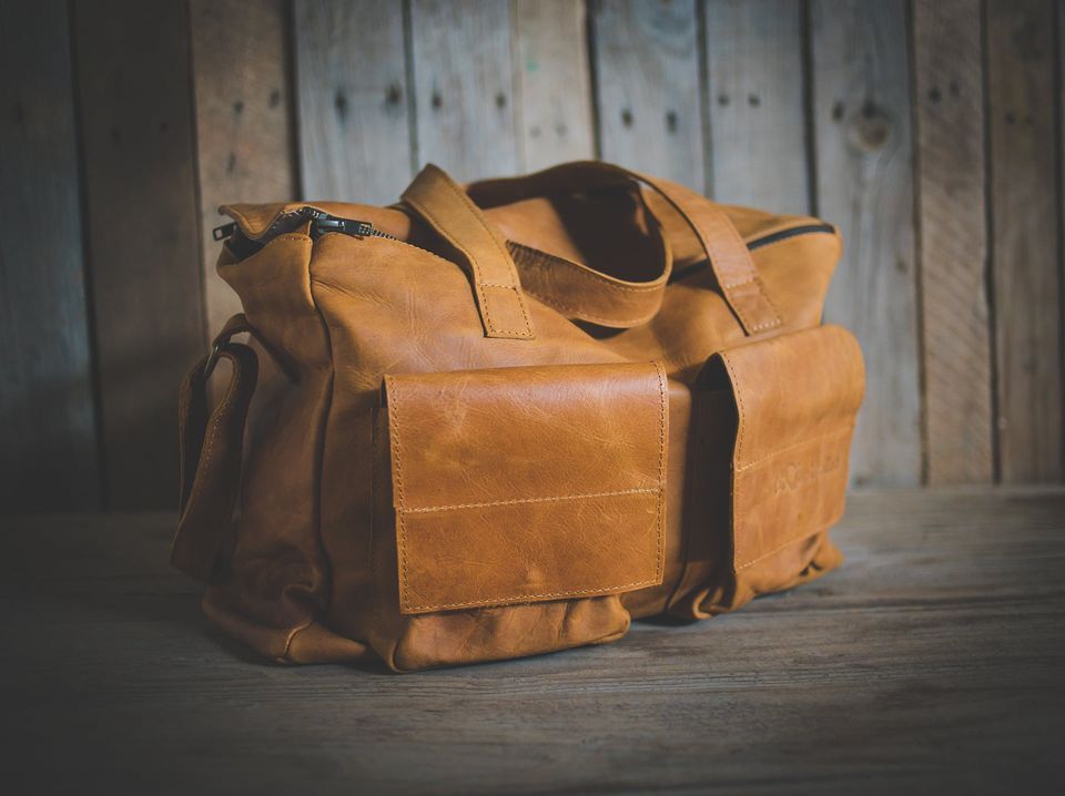 Leather multi-purpose bag on wooden background