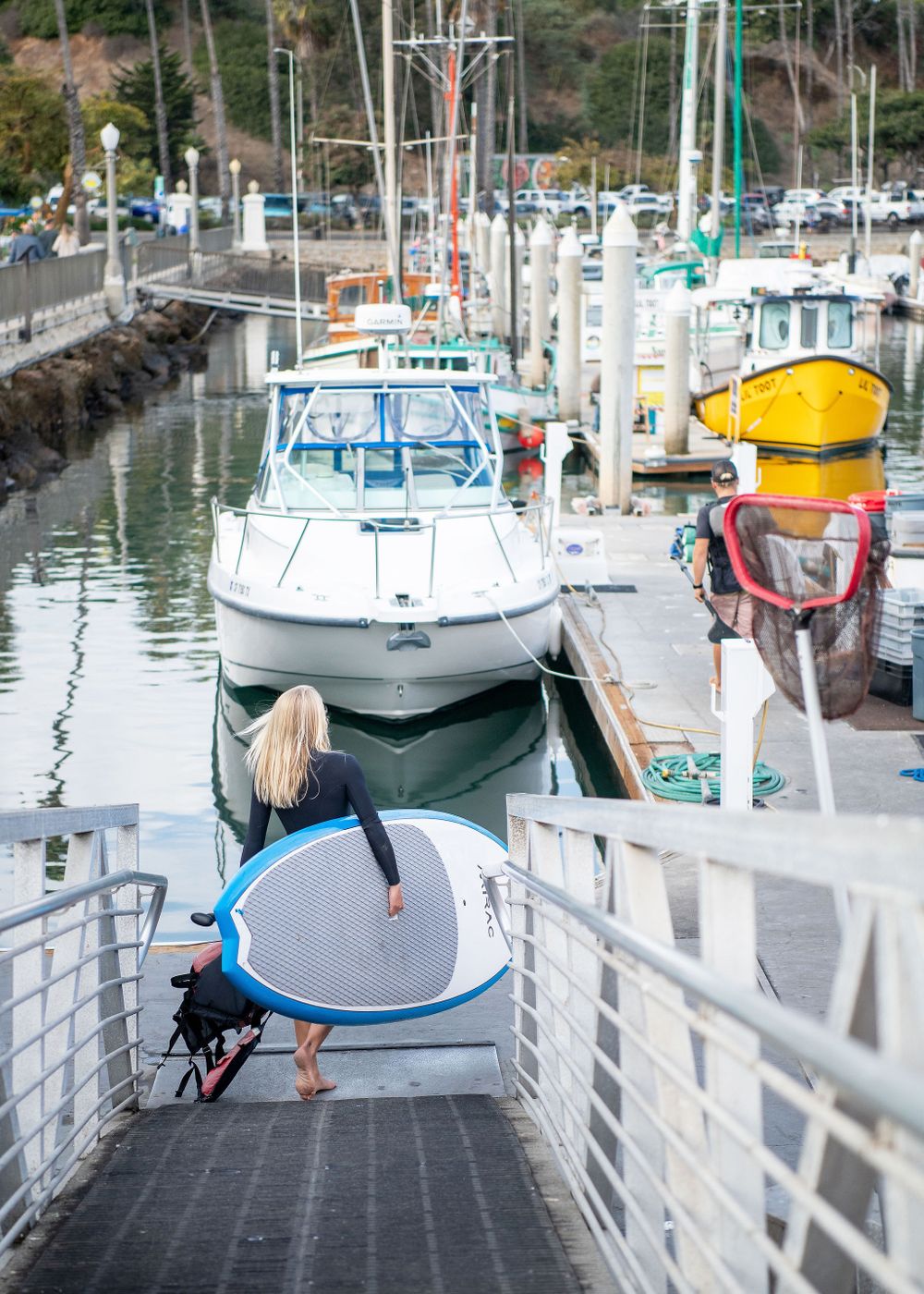 woman carrying paddle board at the santa barbara harbor