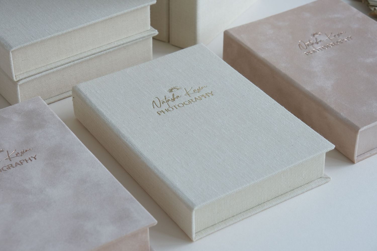 Elegant white wedding album boxes with delicate details arranged in a row.
