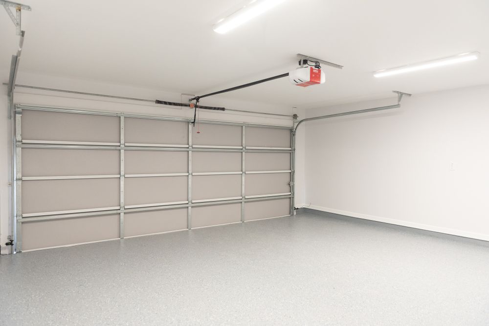 Clean modern garage interior with white walls and grey epoxy flooring.