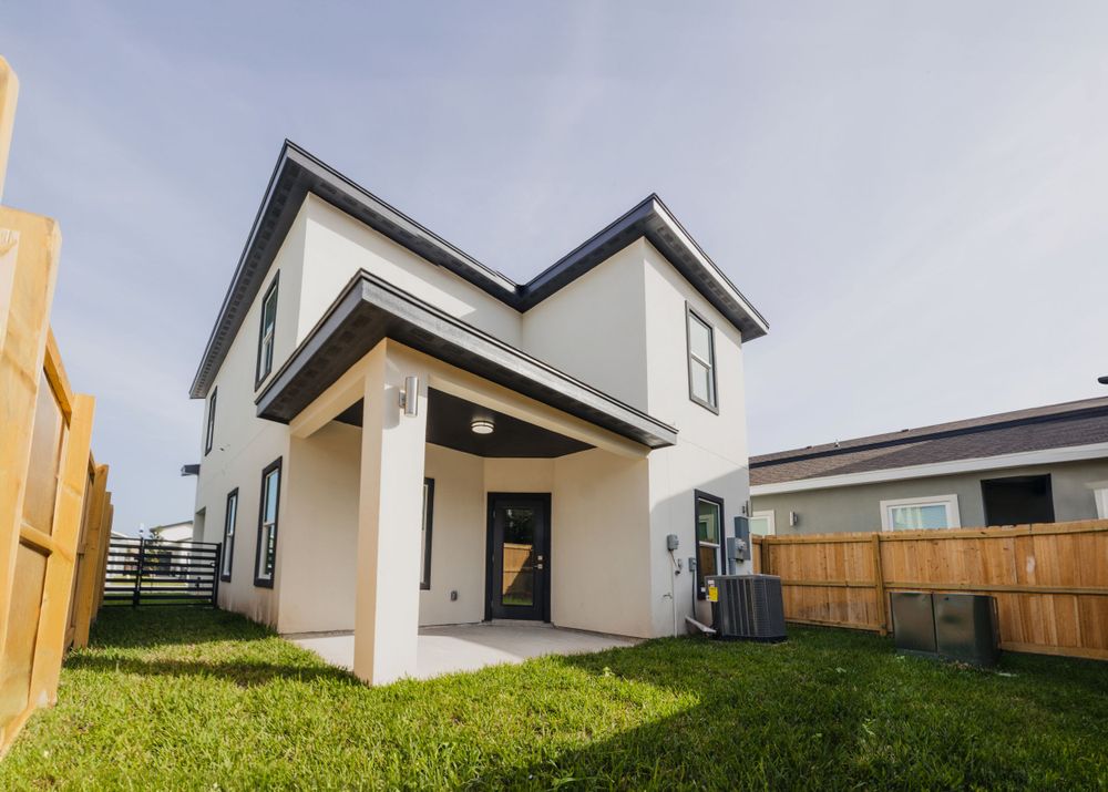 Contemporary two-story home exterior with covered porch and fenced backyard.