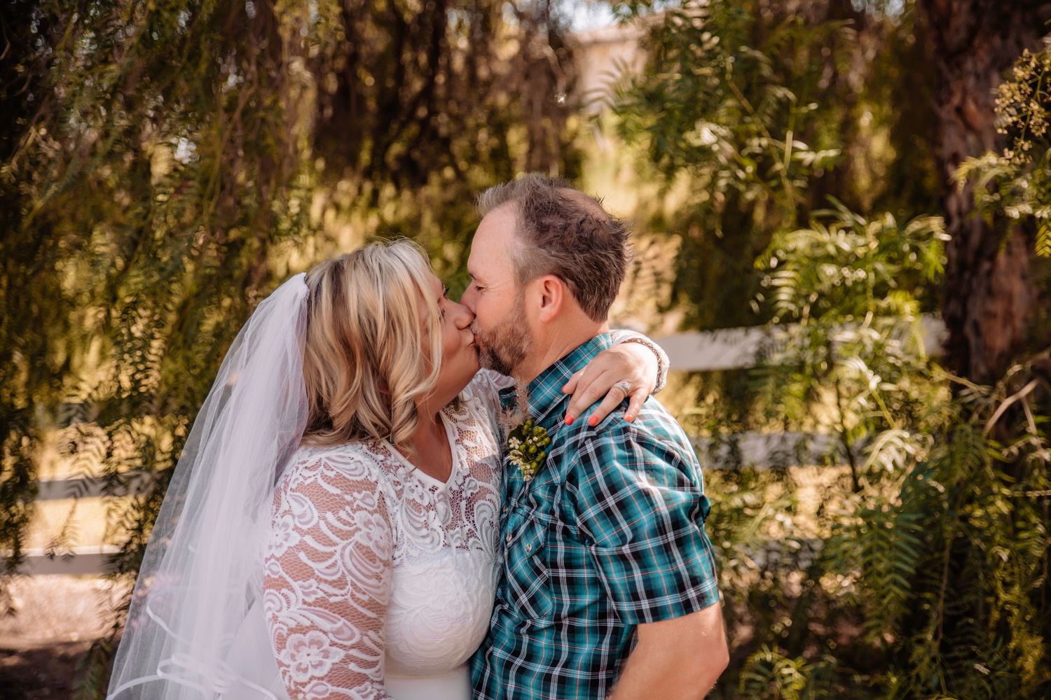 A romantic outdoor wedding photo shoot with string lights and natural scenery in the background.