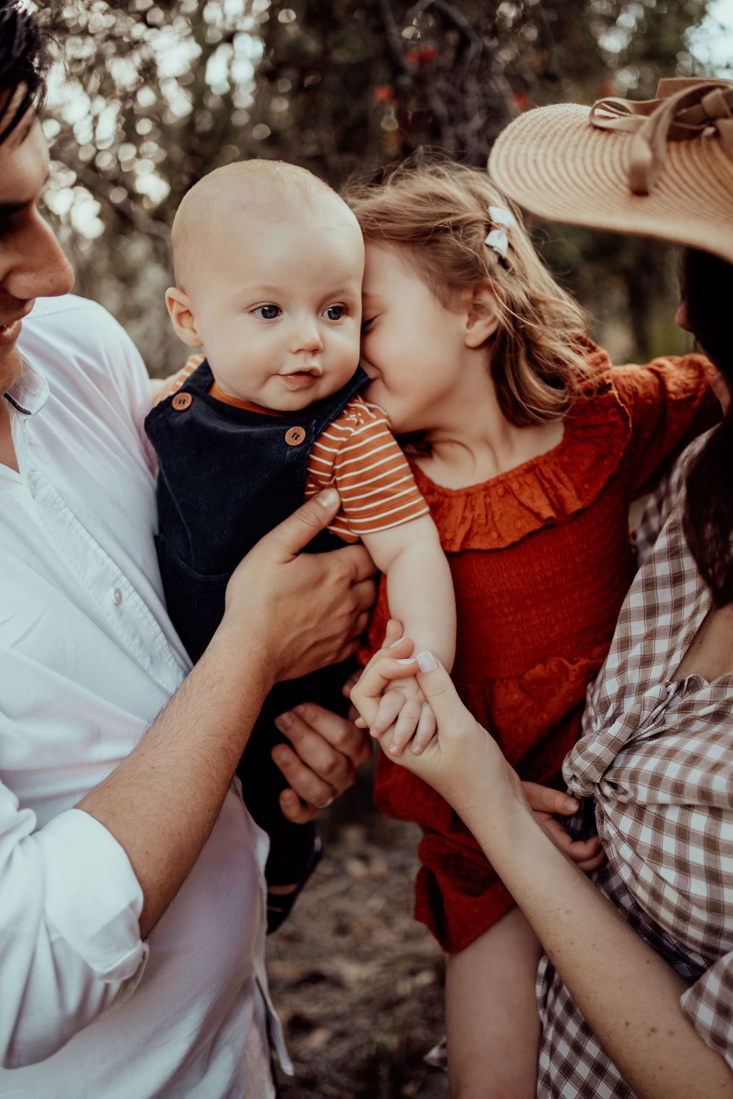 Intimate family moment captured in warm autumn lighting with natural bokeh background.