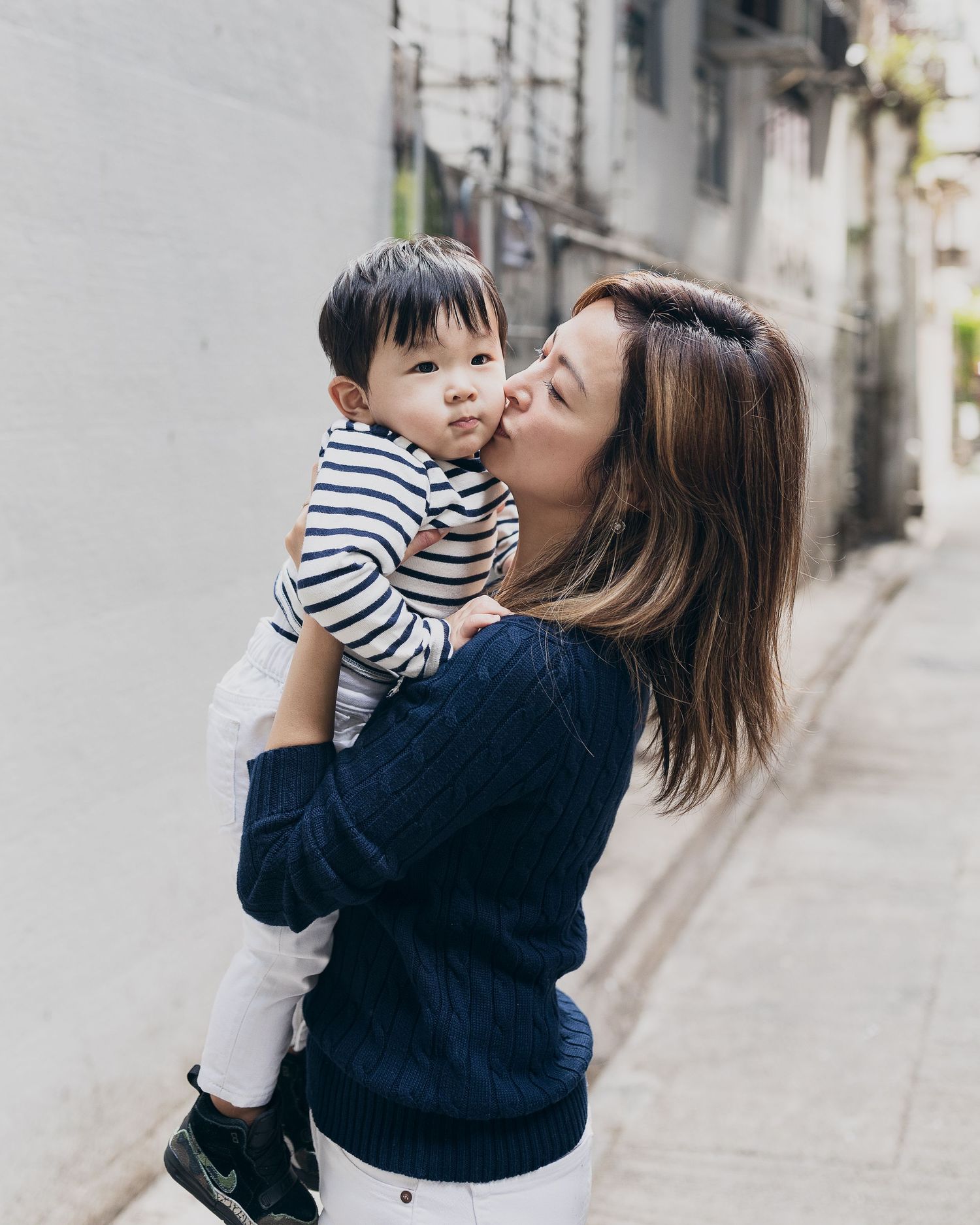 Candid moment between parent and child on urban street.
