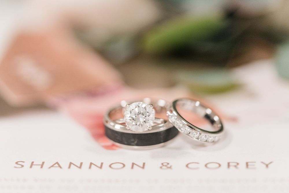 Close-up of elegant wedding rings on custom name card.