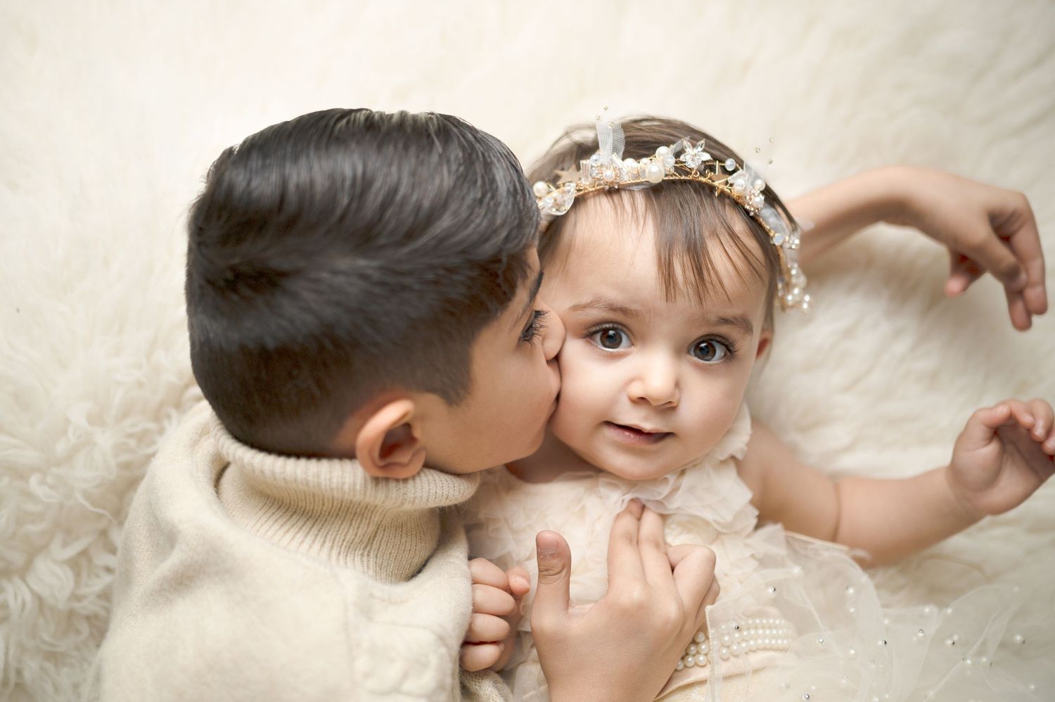 Sweet newborn photography session on cream backdrop with artistic angles.