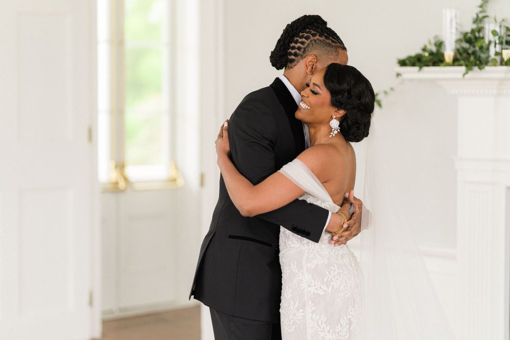 A tender embrace between the newlyweds during their first look in a bright wedding venue.