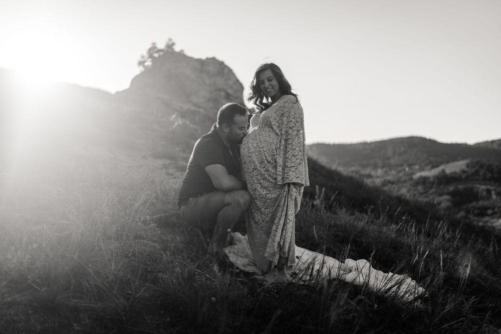 Romantic black and white silhouette against sunlit mountain backdrop.