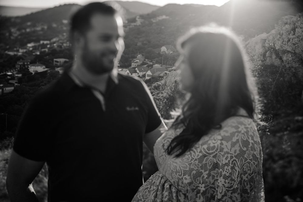 A couple poses against a mountain backdrop during their maternity photography session.