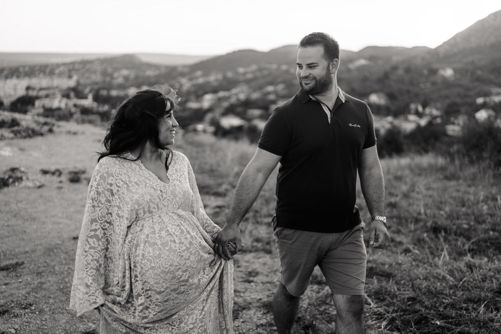 Black and white photo of couple walking together on scenic mountain trail.