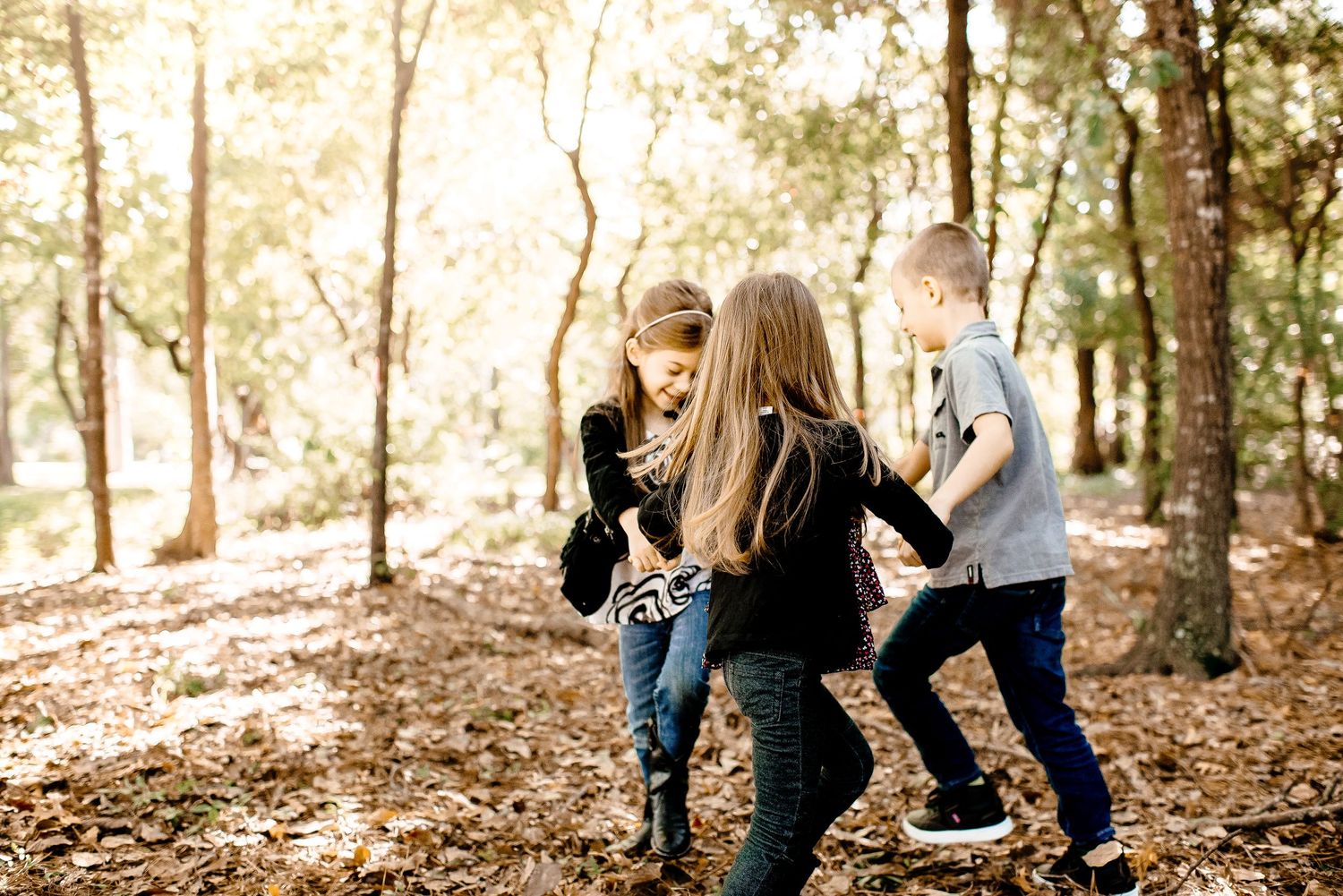 kids playing ring around the roise in a forest in houston, texas