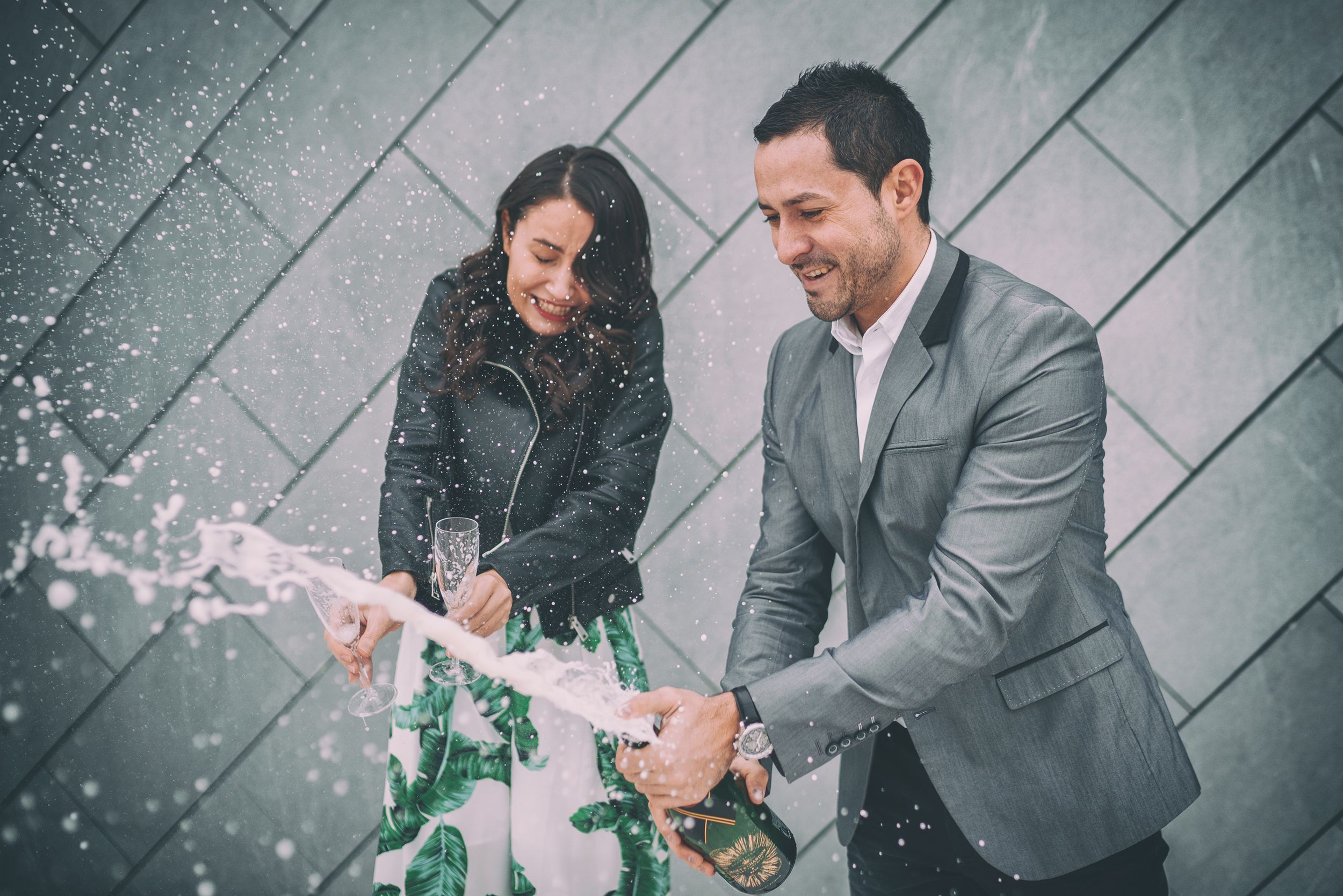 A celebratory moment with champagne spray against a modern geometric background.