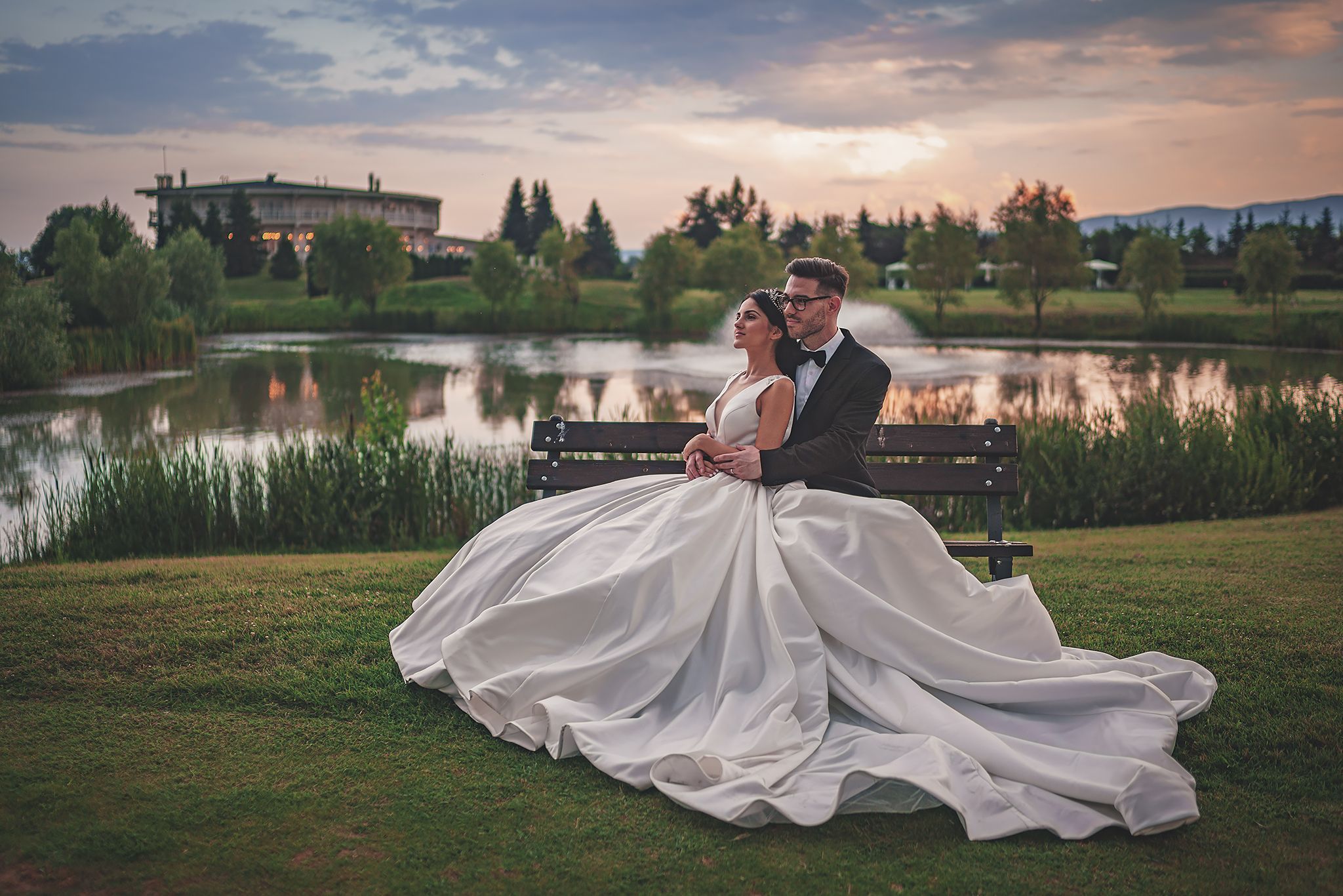 A romantic sunset portrait by a lake with flowing white wedding dress.