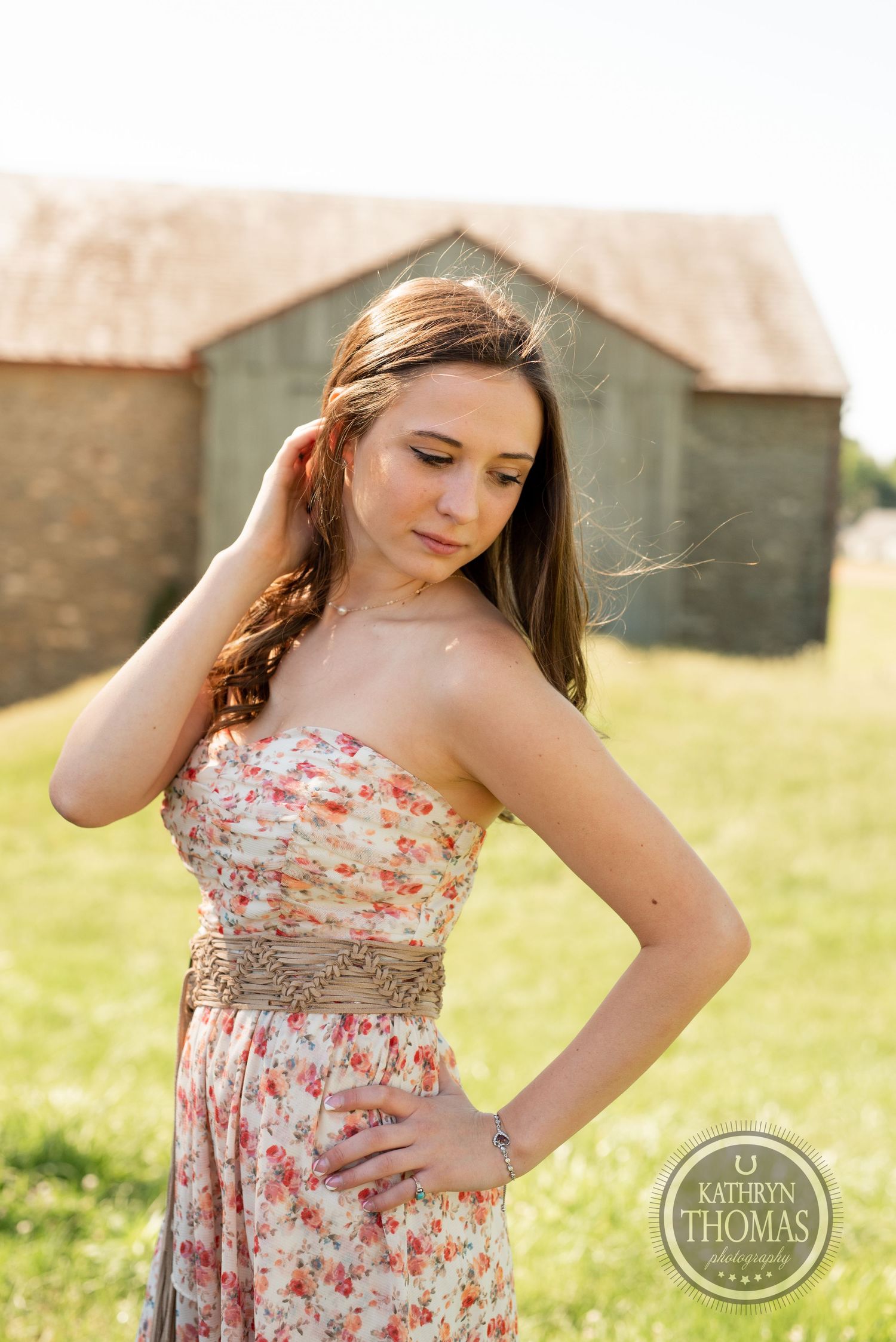 A summer portrait against a rustic barn backdrop in warm afternoon light.