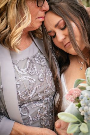 A tender moment captured with embellished gray dress details and soft floral bouquet.