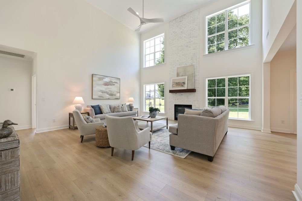 Real estate photography of living room in Winston-Salem featuring hardwood floors and a ceiling fan.