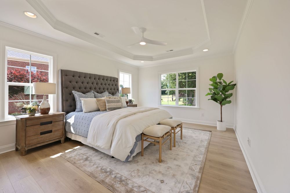 Real estate photography of a light, bright bedroom with beautiful hardwood floors.