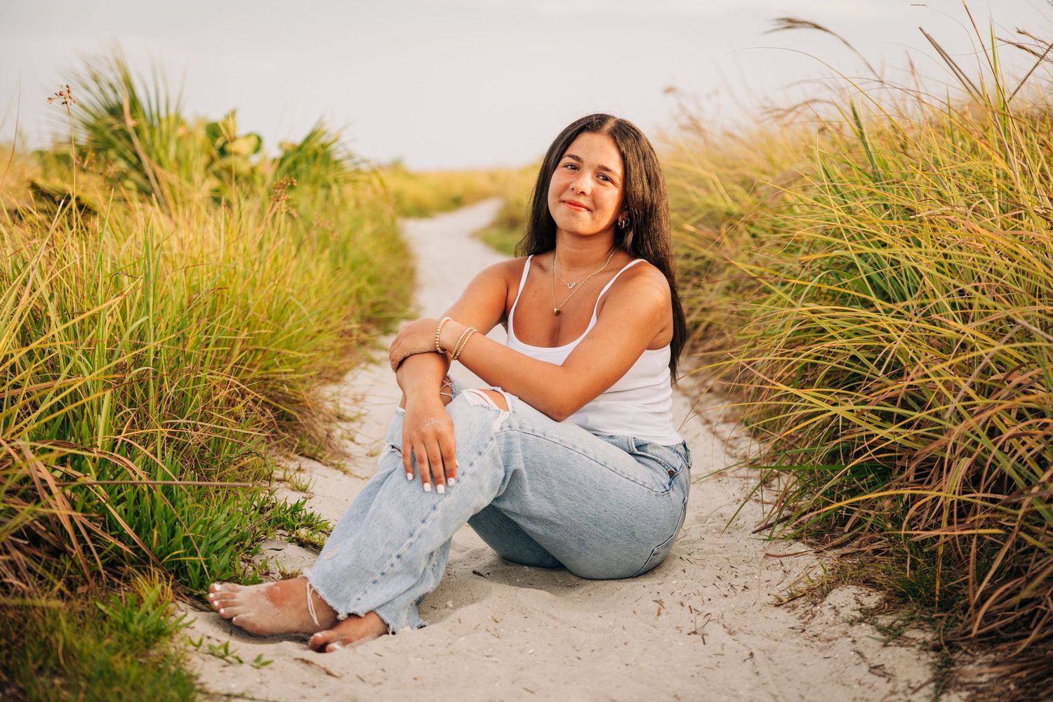 Highschool Senior posing on the path at Siesta Key Beach during sunset taken by Sarasota Family Photographer.