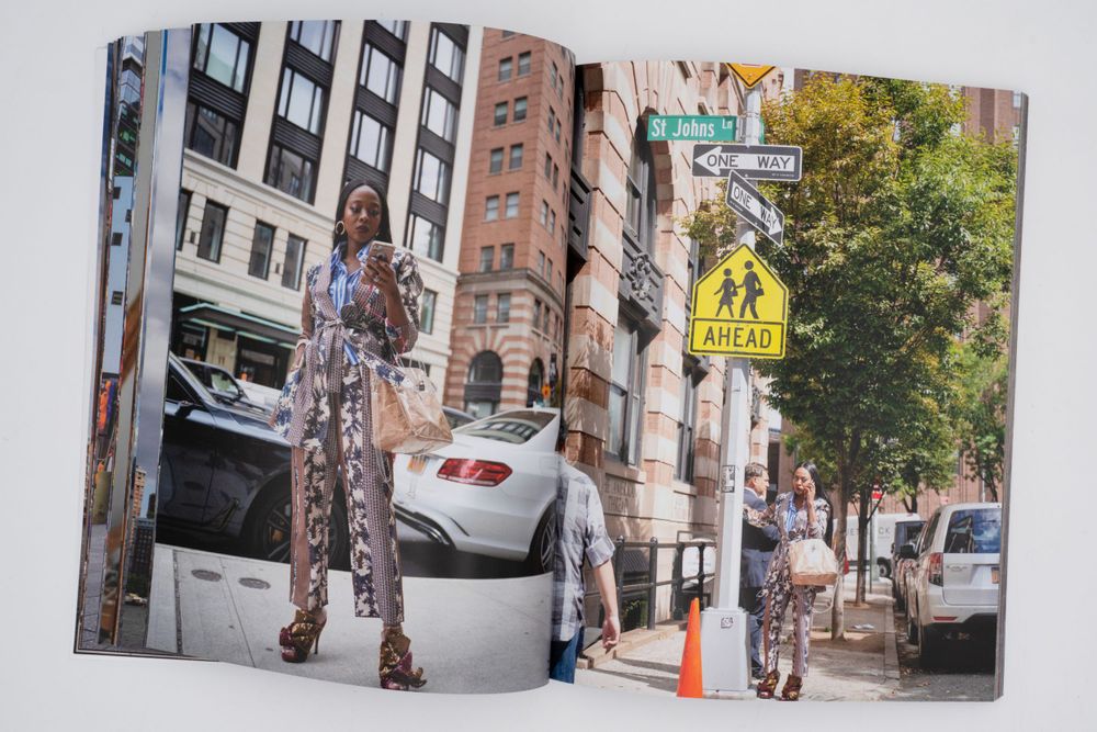 Magazine spread showing urban street scene with brownstone buildings and person in patterned outfit.