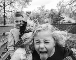 A candid black and white photo capturing spontaneous laughter and joy outdoors.