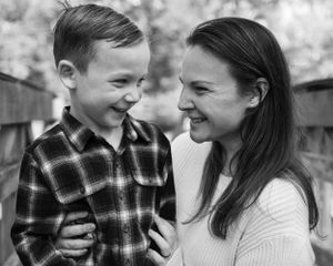 A heartwarming black and white moment of shared laughter and connection between parent and child outdoors.