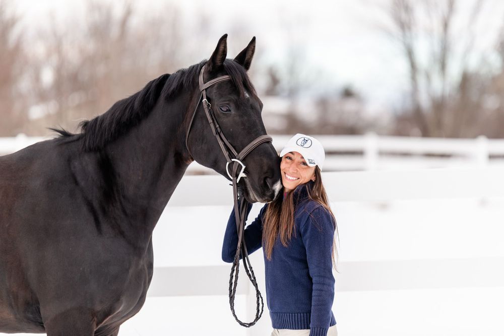 Woman with her cheek pressed against the nose of her horse, winter portrait